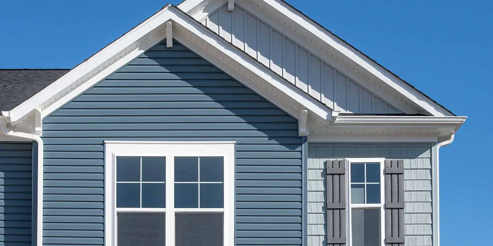 Blue-gray lap siding with a board-and-batten gable and white trim