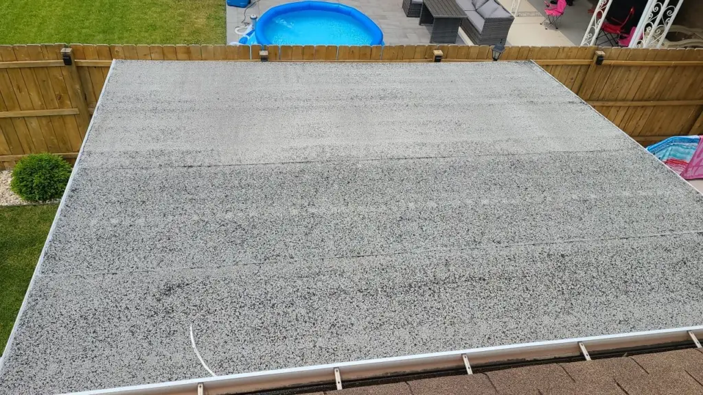 A low-slope roof showing wear and ponding water