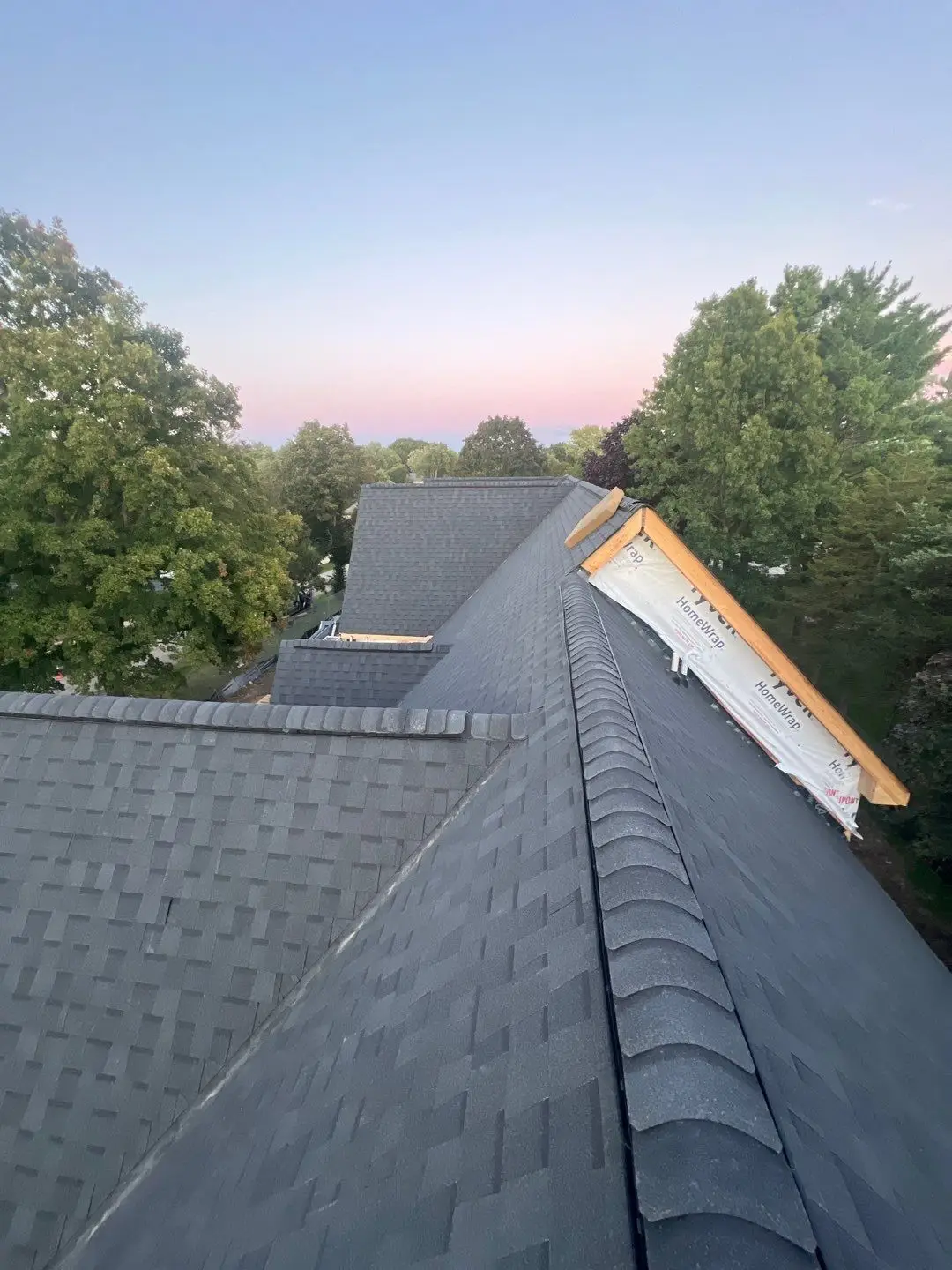 New dark gray shingle roof and ridge cap on a new-construction home