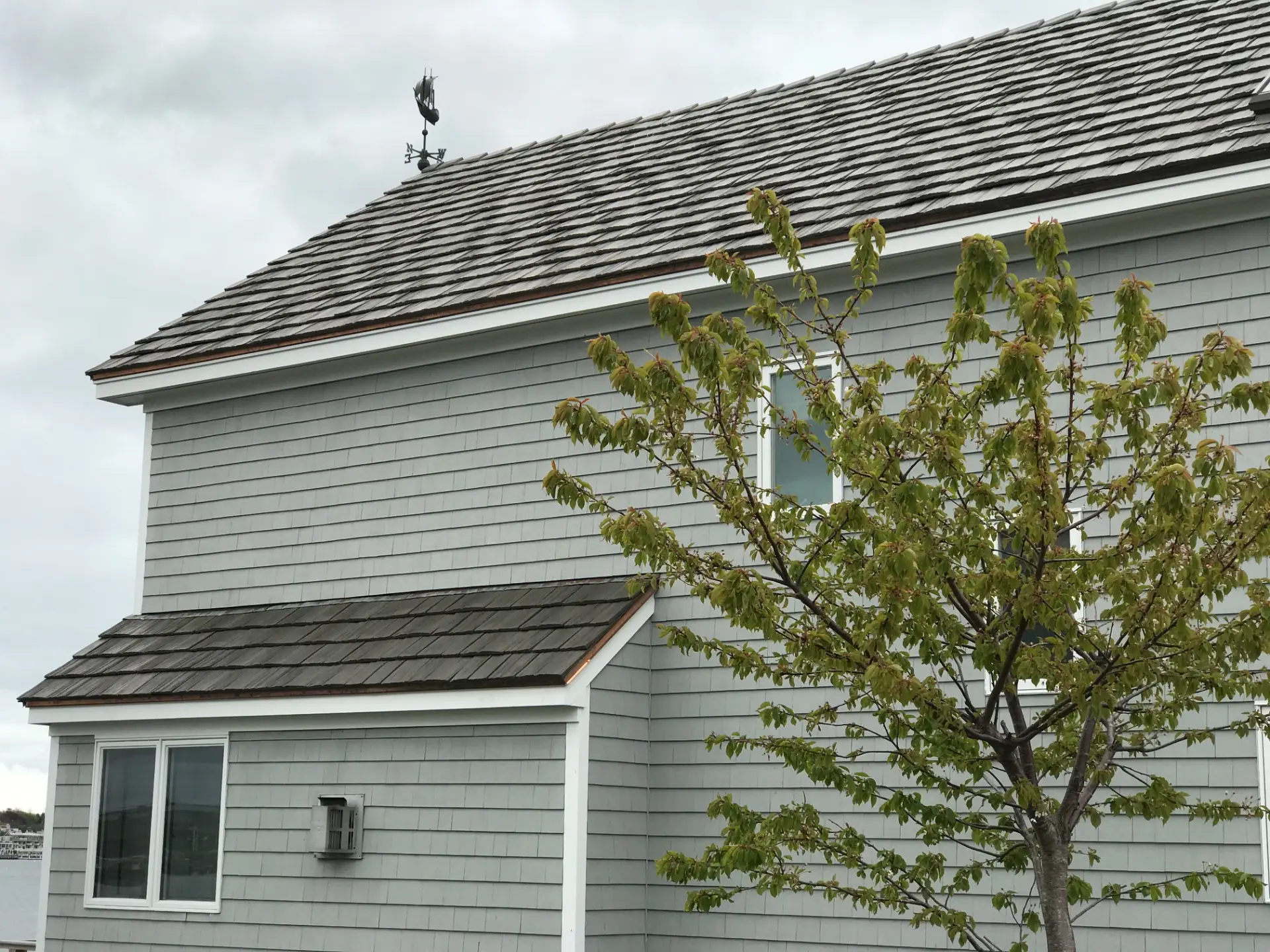 Shake-style roof on a two-story home with gray lap siding