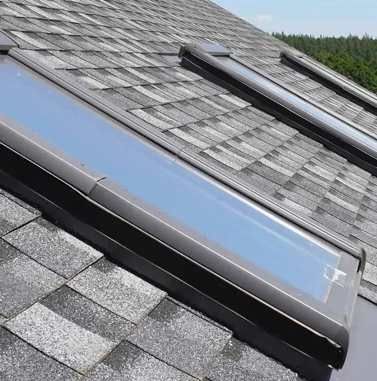 Skylight installed in a gray asphalt shingle roof